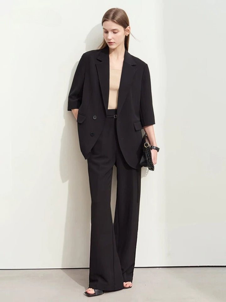 Schwarzer Damen-Hosenanzug mit weitem Blazer, Modell frontal stehend.
