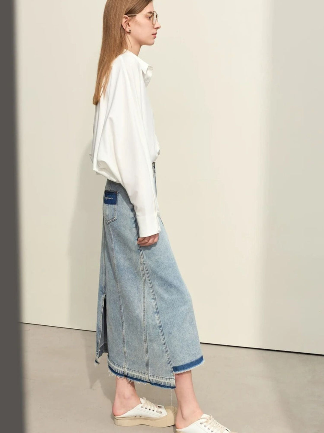 Jeans-Midirock mit Schlitz, seitliche Ansicht des Modells.