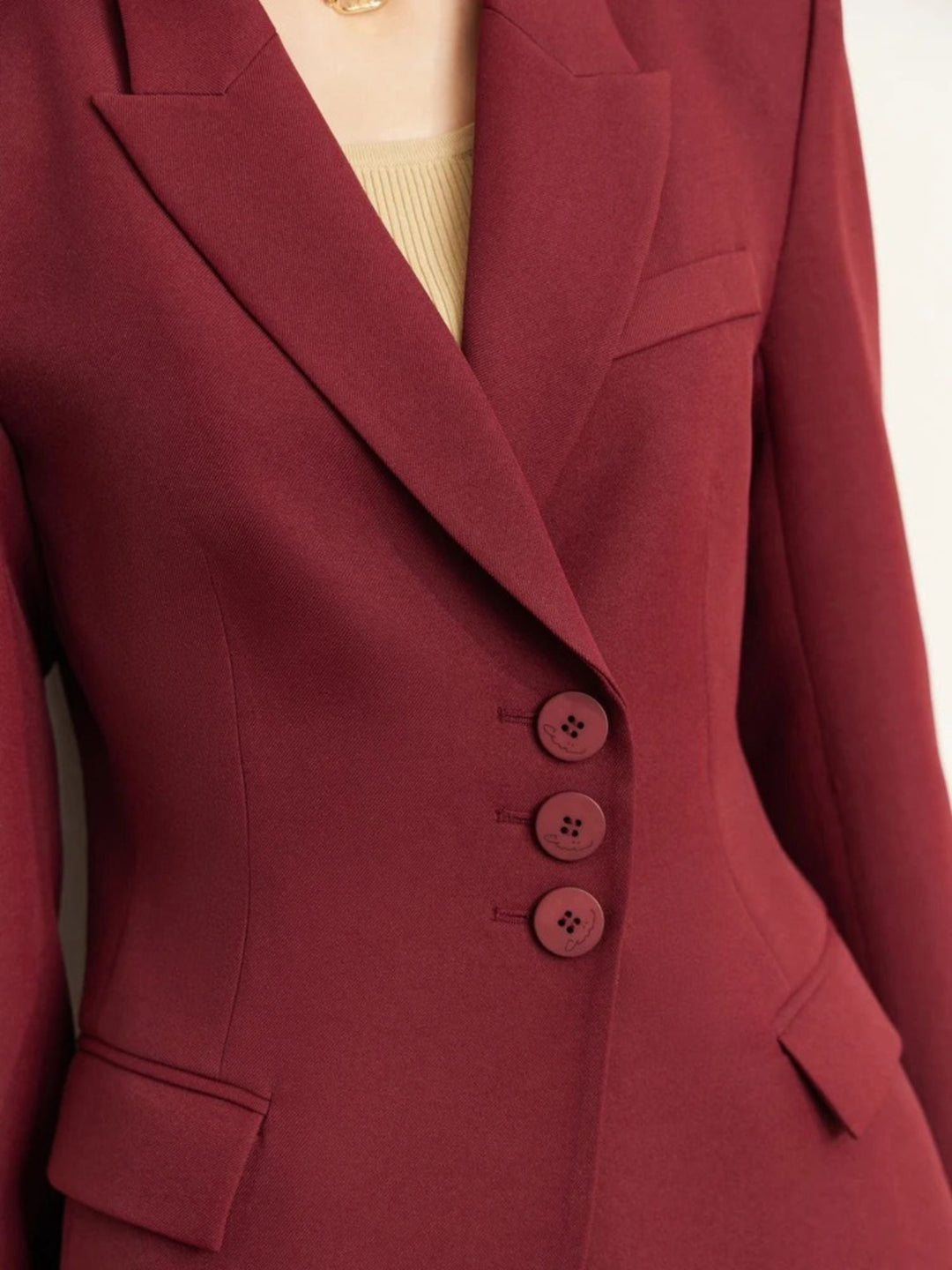 Detailaufnahme: Knopfleiste des dunkelroten Blazers.