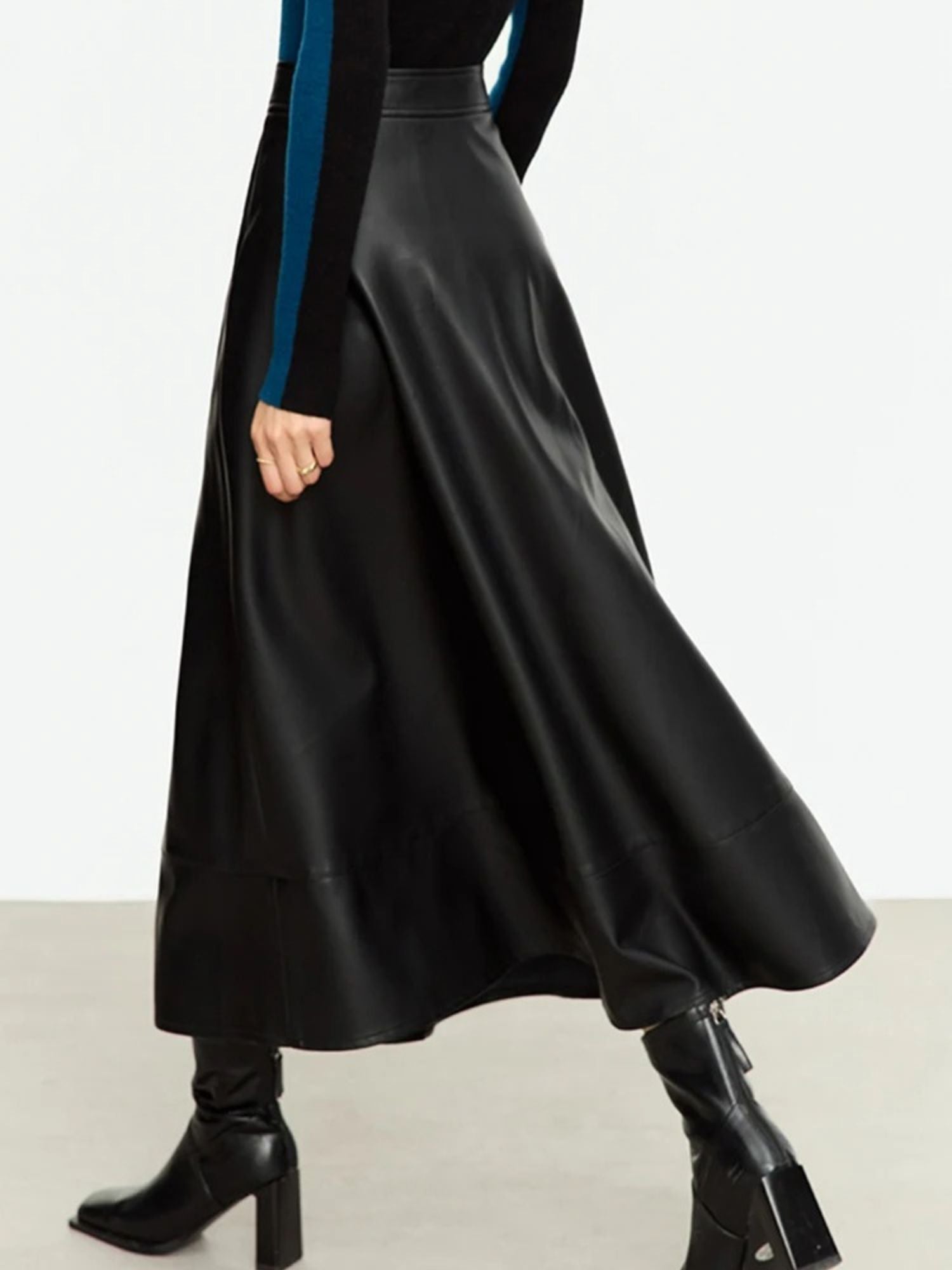 Brauner Kunstleder-Midirock, Modell seitlich mit grünem Pullover.