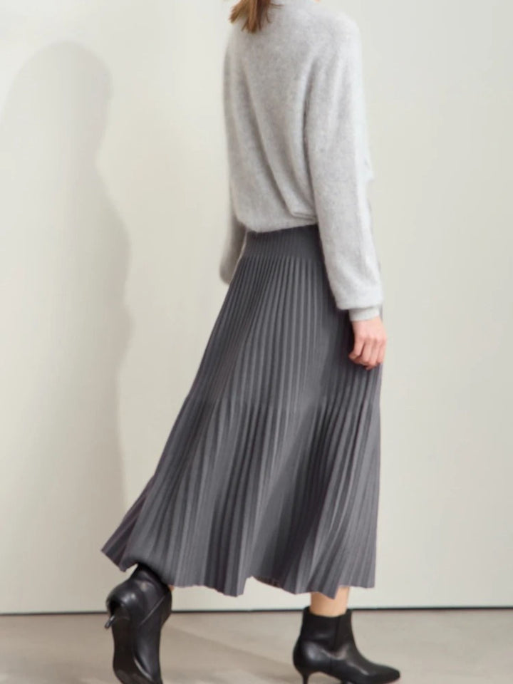 Grauer Plisseerock mit Farbkontrast, Modell frontal mit Stiefeletten.