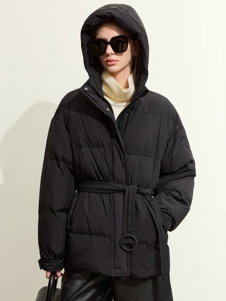 Schwarzer Daunenmantel mit Kapuze, geschlossen, Modell mit Sonnenbrille.